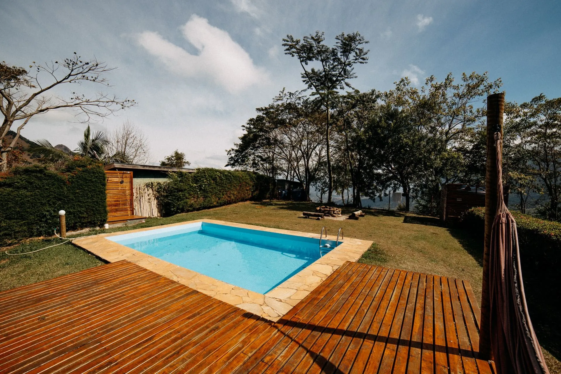 Timber deck surrounding a backyard plunge pool, one of many deck ideas for warm climates