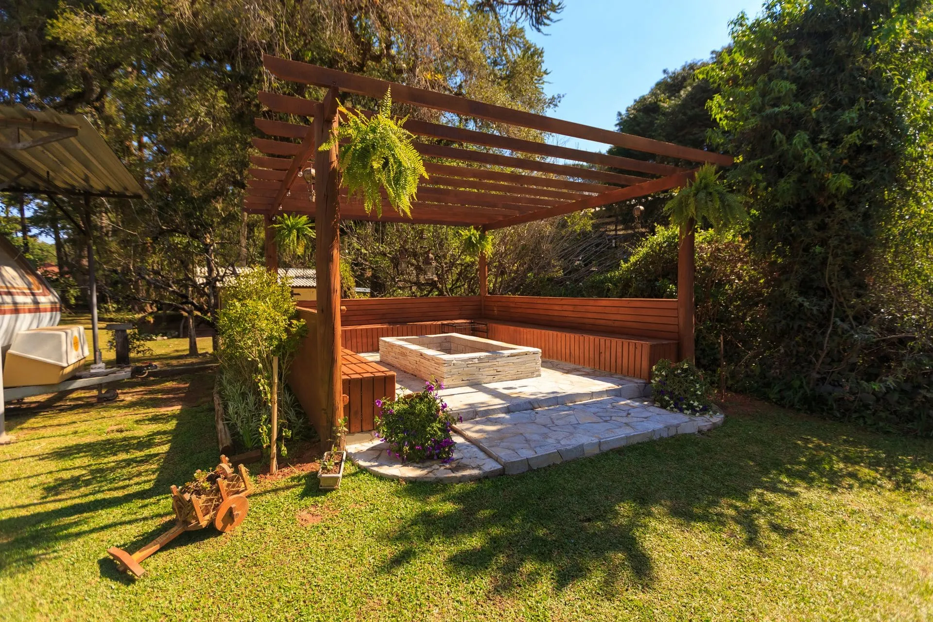 Timber pergola with built-in bench seating in a sunny garden, a backyard pergola idea