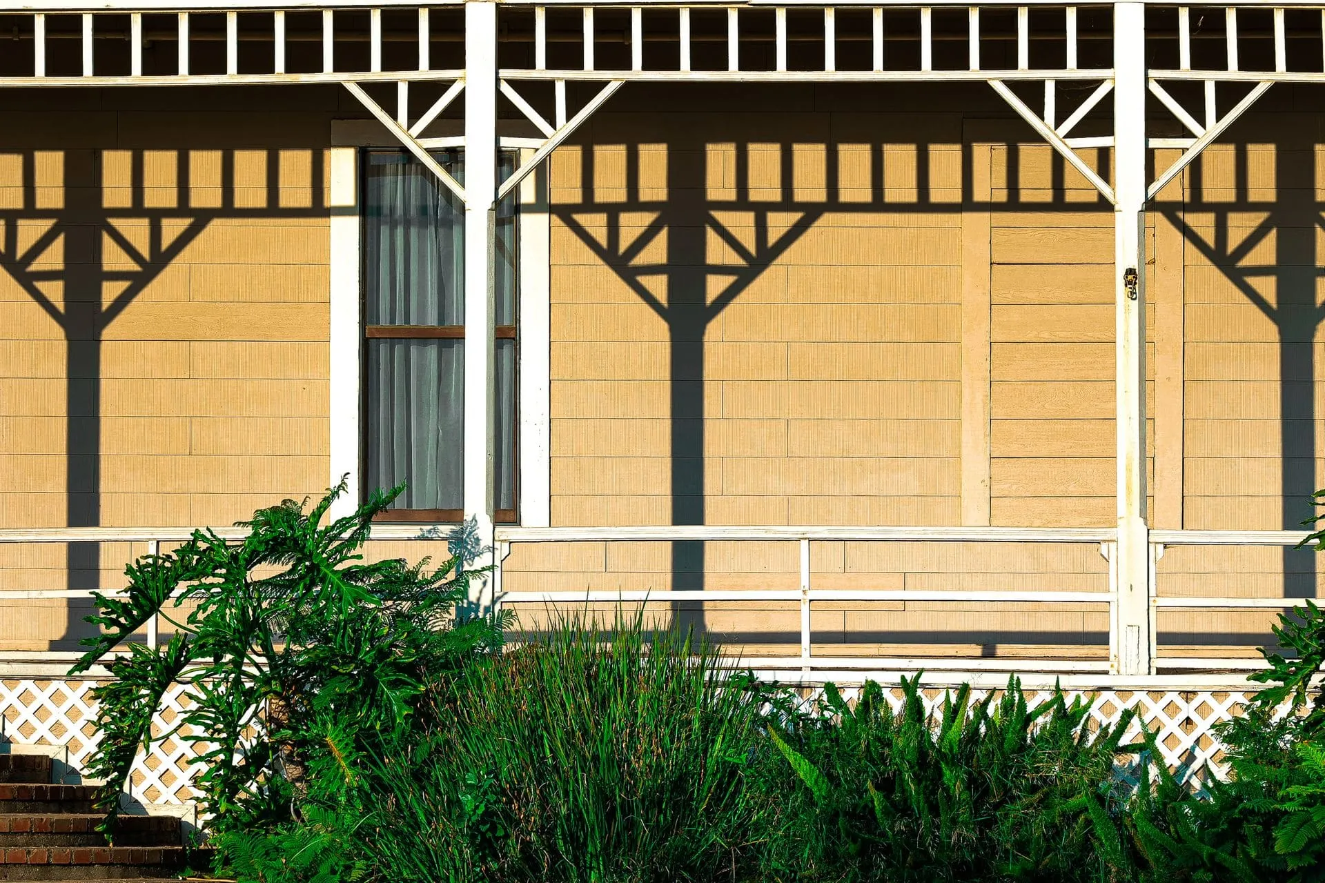 Classic verandah with posts and decorative trim along a home, compared in pergola vs verandah