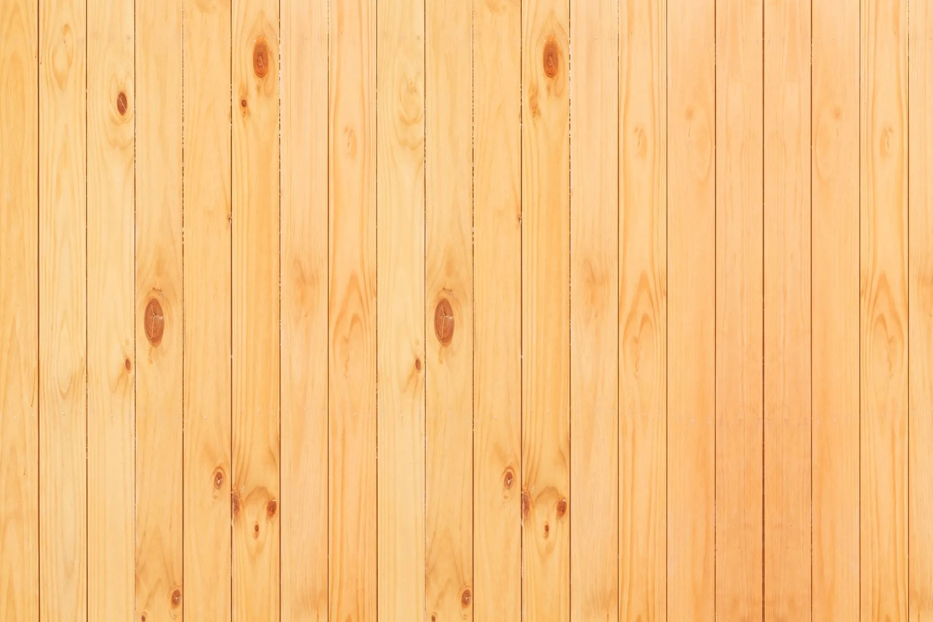 Pale pine boards with visible knots, the look of treated pine decking before oiling